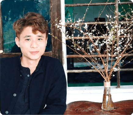 Nguyễn Đình Long bên bình hoa trắng